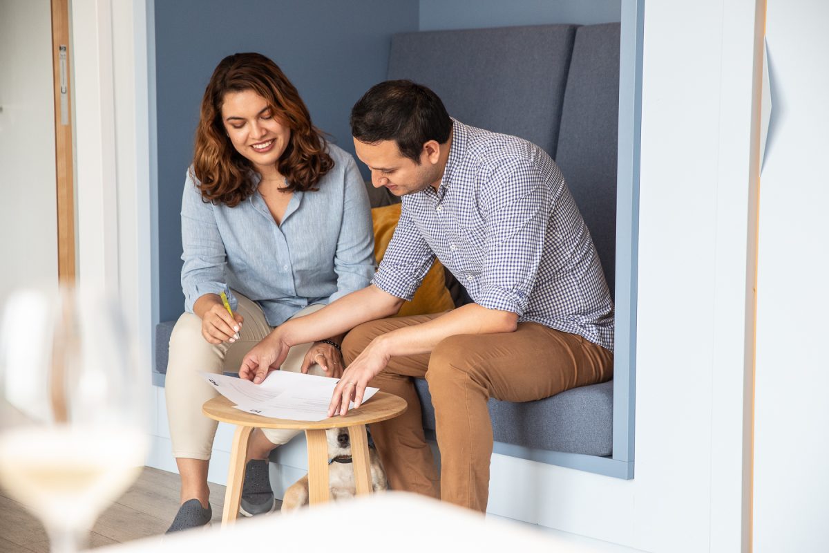 two colleagues are working together sitting side by side taking notes